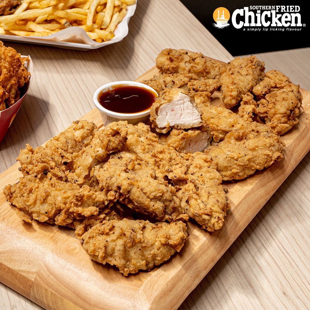 Boneless southern fried chicken strips in a serving tray outdoors.